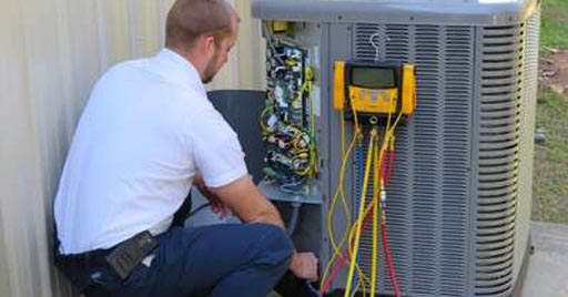 A HVAC technician inspects the air conditioning fan electronics.