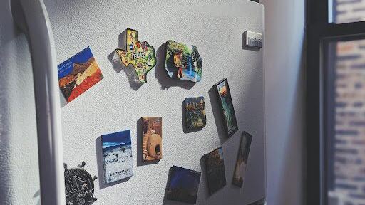 A refrigerator covered in decorative magnets.