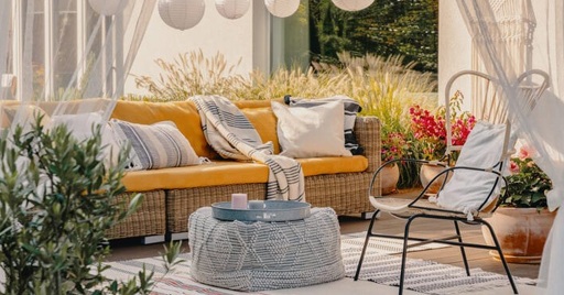 An outdoor patio with couches, seats, and curtains for shade.