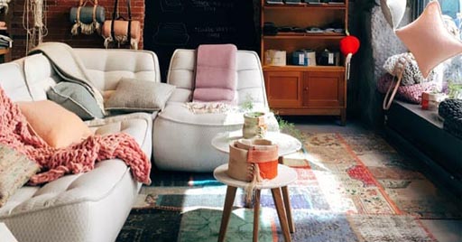 A cozy living room with a couch and large windows.