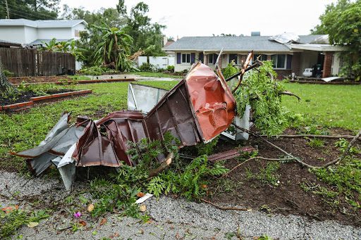 A storm-damaged shed in a backyard.