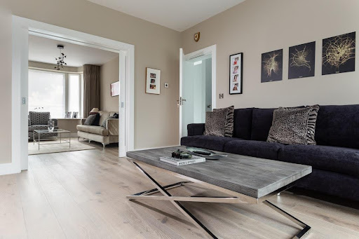 A living room with grey laminate flooring that resembles stained hardwood flooring.