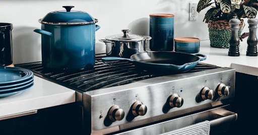 A gas stove with pots and pans on it.