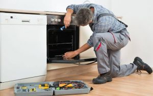 A repair professional inspecting an oven.