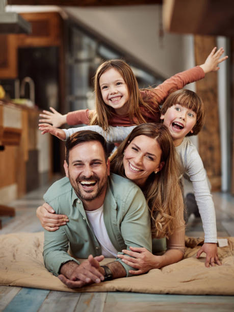 Family of three smiling on couch in their home.